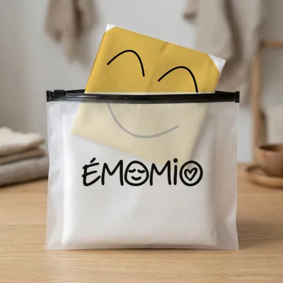 La housse de la joie pliée dans sa pochette zippée translucide Émomio.